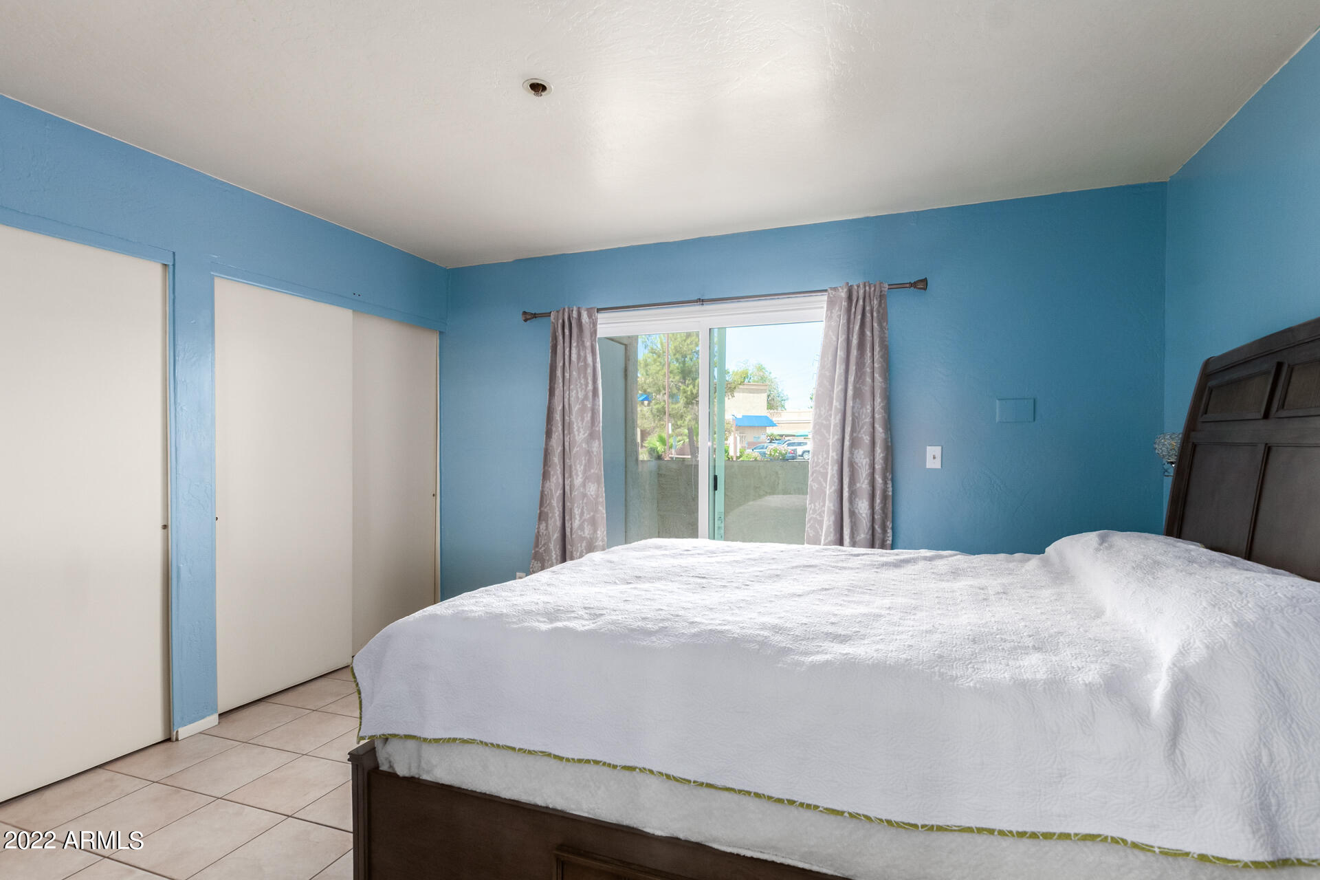 12123 West Bell Road, Unit 159 Surprise, AZ 85378 - Photo 9 of 21 a large bed sitting in a bedroom next to a window