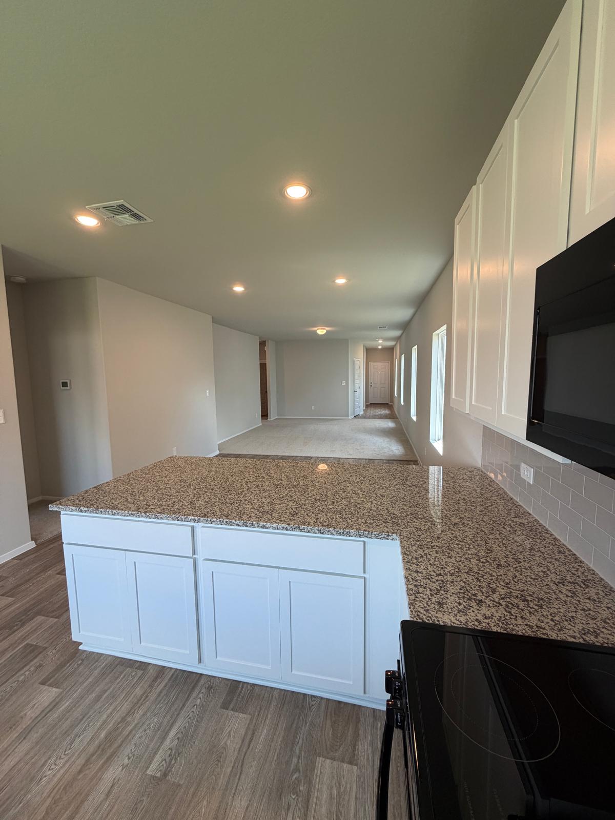2612 Towy Road Manor, TX 78653 - Photo 25 of 35 A well-appointed kitchen island offers generous counter space, perfectly complementing the seamless open-concept living area.