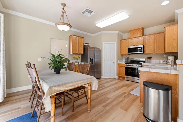 a kitchen with granite countertop wooden floor stainless steel appliances and wooden floor
