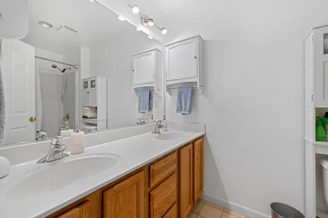 a bathroom with a sink vanity granite tub shower and a mirror