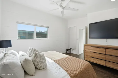 a bedroom with a bed and a flat screen tv