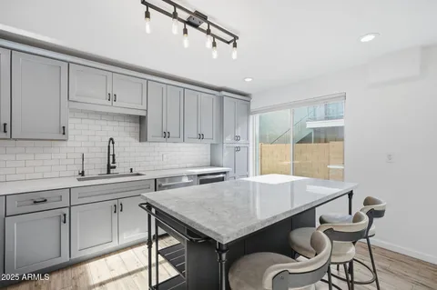a kitchen with a table chairs sink and cabinets