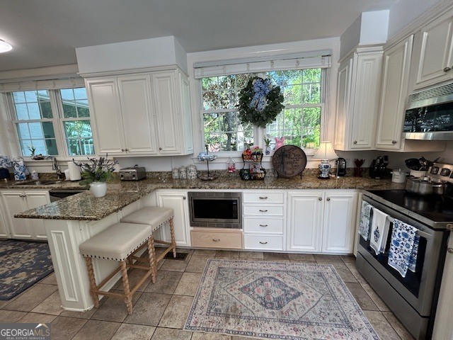 1156 South Main Street Moultrie, GA 31768 - Photo 26 of 56 a kitchen with stainless steel appliances granite countertop a stove a sink and a microwave