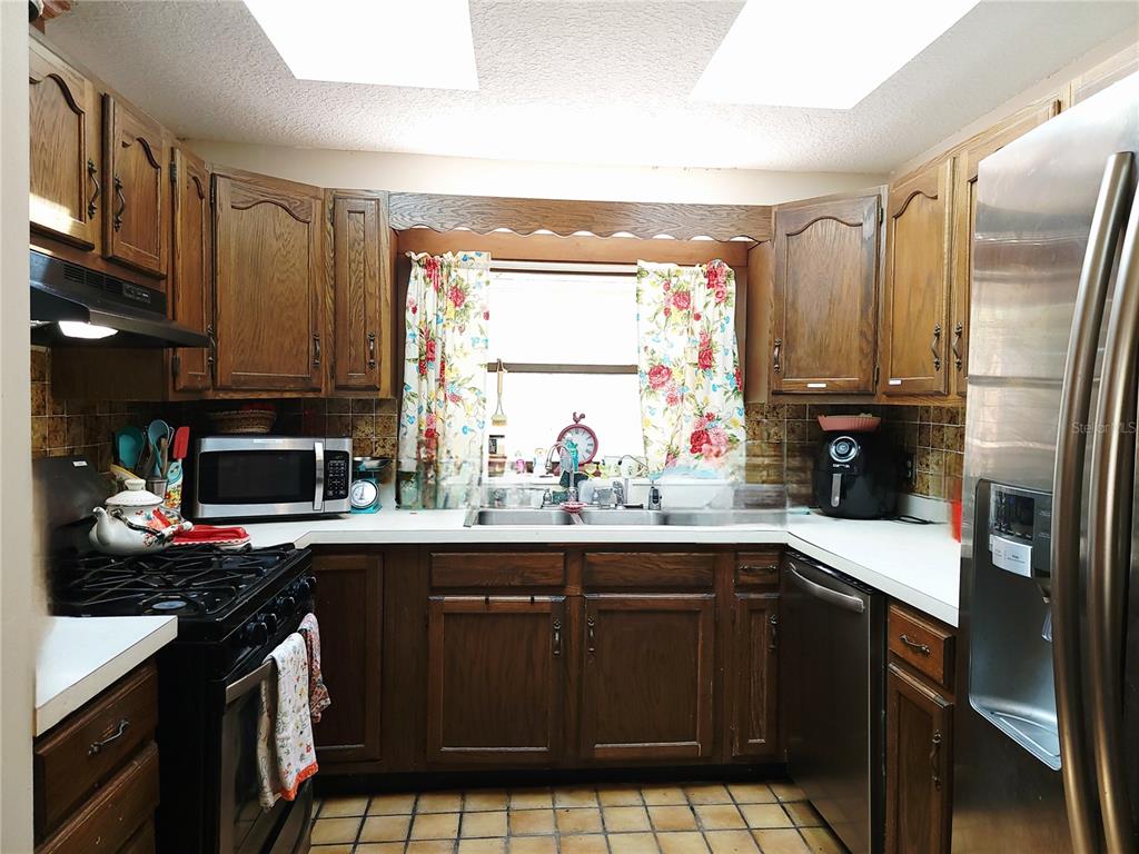 1600 Southwest 42nd Street Ocala, FL 34471 - Photo 11 of 39 a kitchen with a sink stove and refrigerator