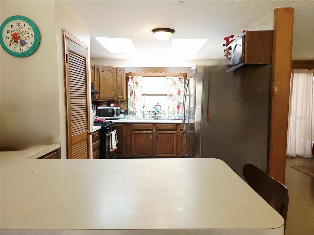 1600 Southwest 42nd Street Ocala, FL 34471 - Photo 12 of 39 a kitchen with stainless steel appliances a sink a stove a refrigerator and a window