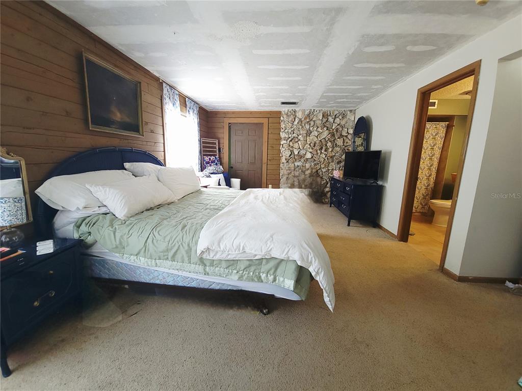 1600 Southwest 42nd Street Ocala, FL 34471 - Photo 17 of 39 a bedroom with a bed flat screen tv and a large window