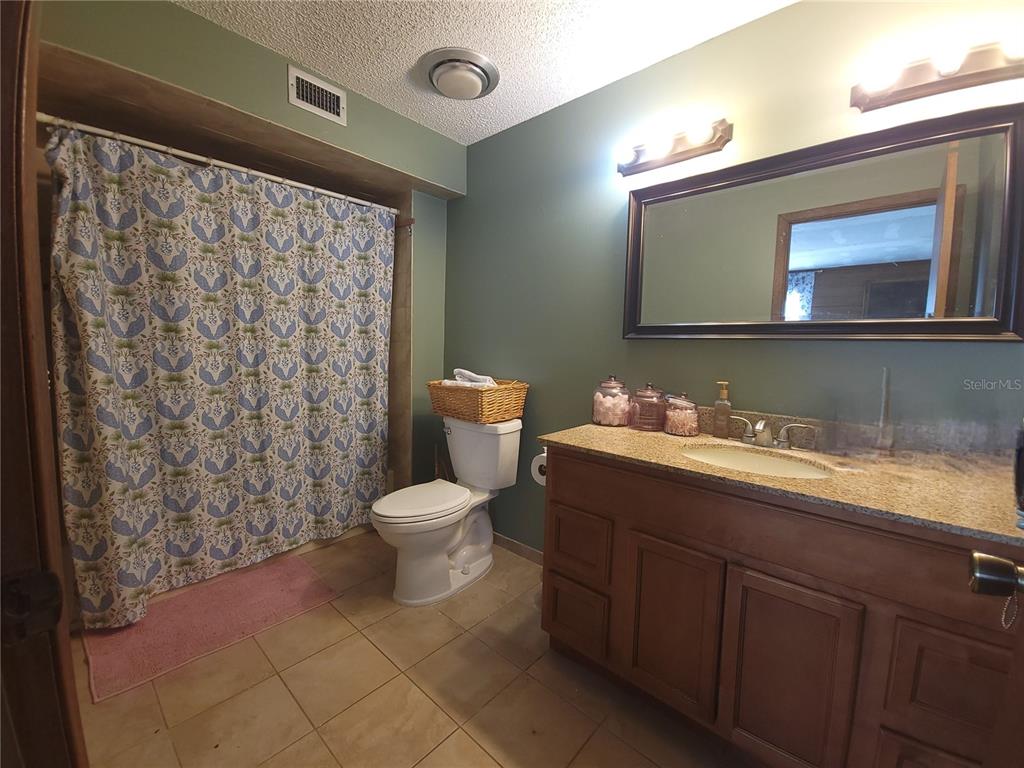 1600 Southwest 42nd Street Ocala, FL 34471 - Photo 19 of 39 a bathroom with a granite countertop sink mirror and toilet
