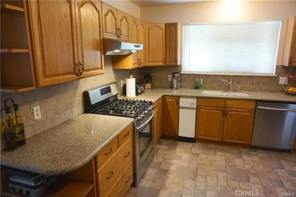 a kitchen with a sink stove and cabinets