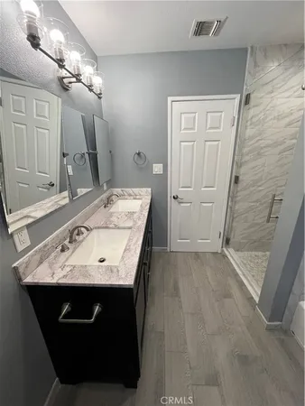 a bathroom with a sink vanity granite and a mirror