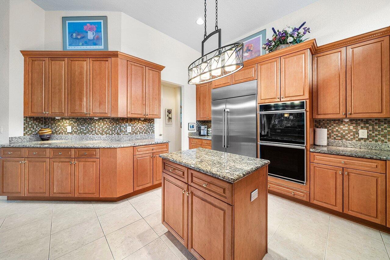 7094 Vía Mediterrania Boca Raton, FL 33433 - Photo 11 of 46 a kitchen with stainless steel appliances granite countertop a stove refrigerator and cabinets