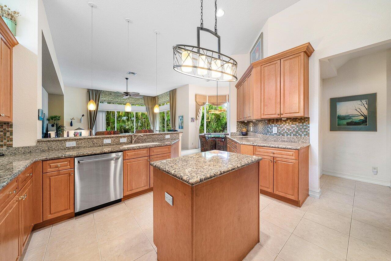 7094 Vía Mediterrania Boca Raton, FL 33433 - Photo 12 of 46 a kitchen with stainless steel appliances granite countertop wooden cabinets a sink a center island and a window