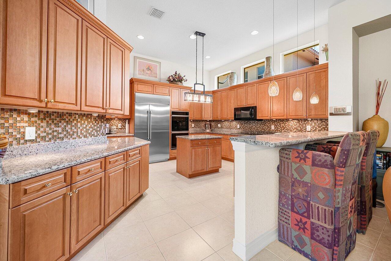 7094 Vía Mediterrania Boca Raton, FL 33433 - Photo 13 of 46 a kitchen with stainless steel appliances granite countertop a stove a sink and a microwave