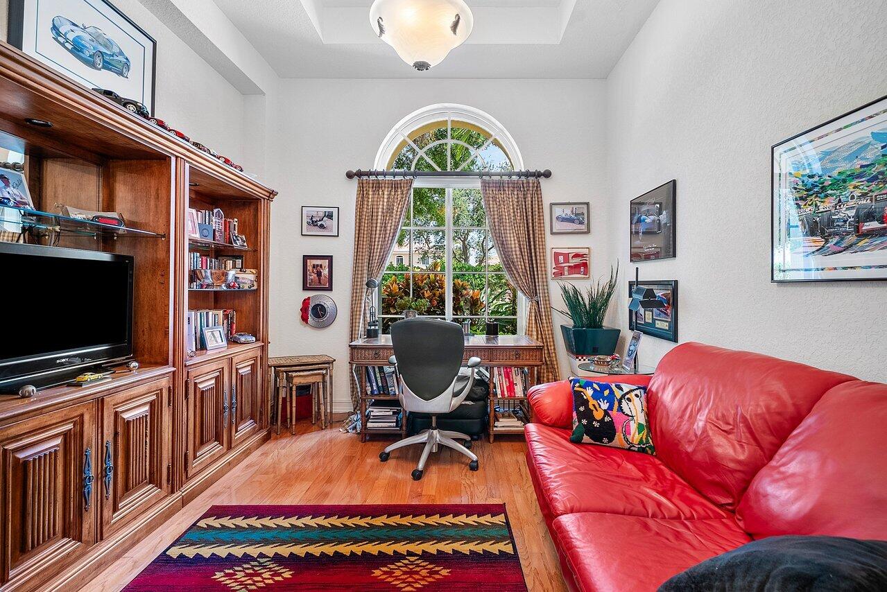 7094 Vía Mediterrania Boca Raton, FL 33433 - Photo 19 of 46 a living room with furniture a flat screen tv and a floor to ceiling window