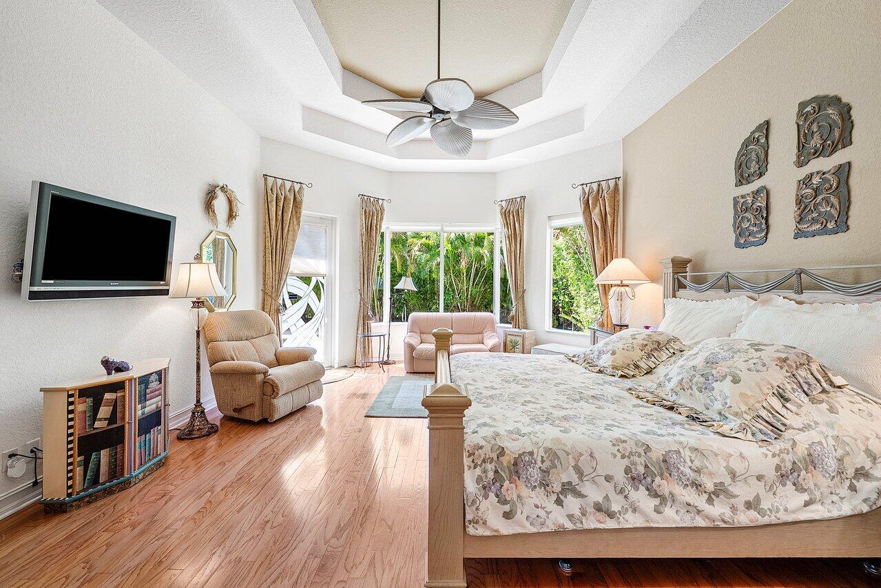 7094 Vía Mediterrania Boca Raton, FL 33433 - Photo 24 of 46 a bedroom with a large bed and a flat screen tv