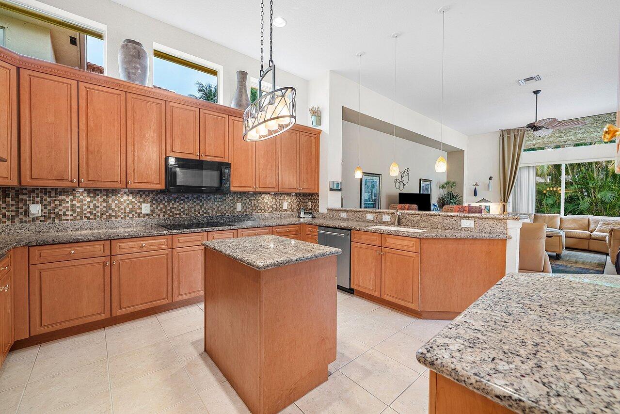 7094 Vía Mediterrania Boca Raton, FL 33433 - Photo 10 of 46 a kitchen with stainless steel appliances granite countertop wooden cabinets a sink and a counter
