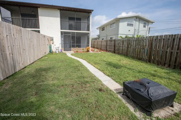 a view of a backyard with potted plants and wooden fence