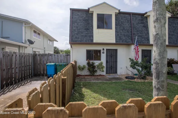a view of backyard with seating space and wooden fence
