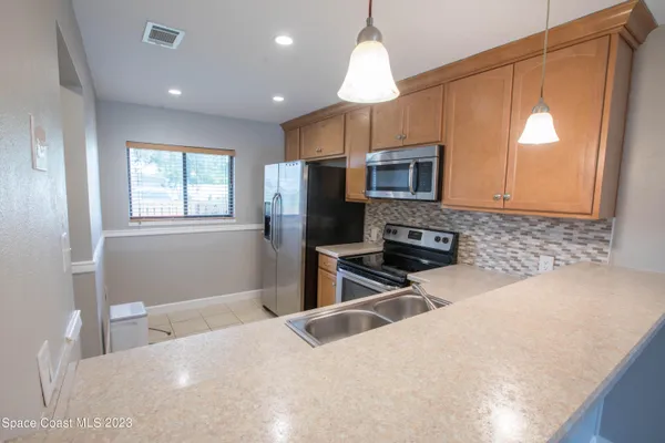 a kitchen with a refrigerator a microwave oven a sink and a counter top space