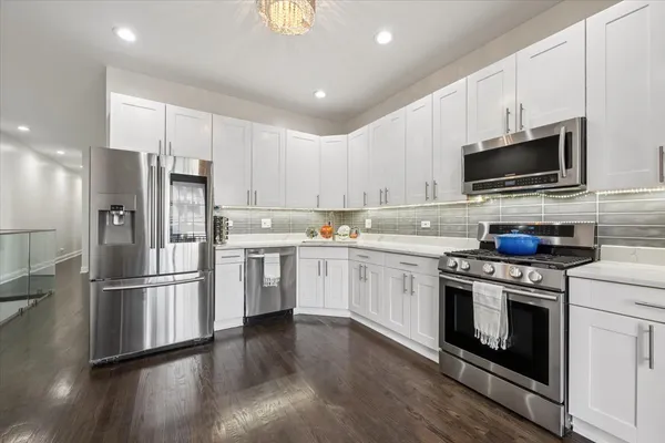 a kitchen with stainless steel appliances a refrigerator stove and microwave