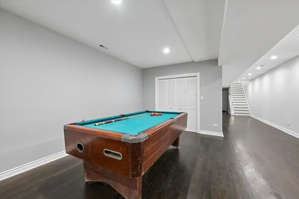 a room with wooden floor and pool table