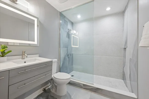 a bathroom with a toilet sink vanity and mirror