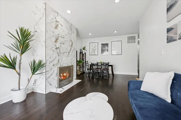 a living room with furniture a fireplace a potted plant and a fireplace