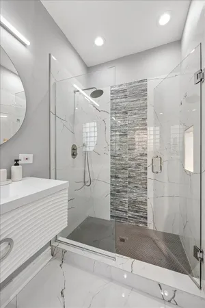 a bathroom with a shower a sink and mirror
