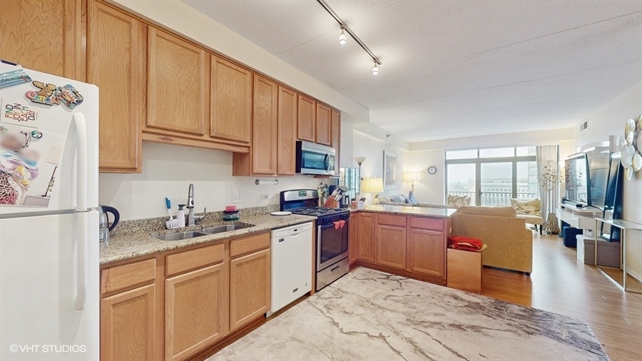 1250 South Indiana Avenue, Unit 1002 Chicago, IL 60605 - Photo 11 of 25 a kitchen with granite countertop a sink stove and refrigerator