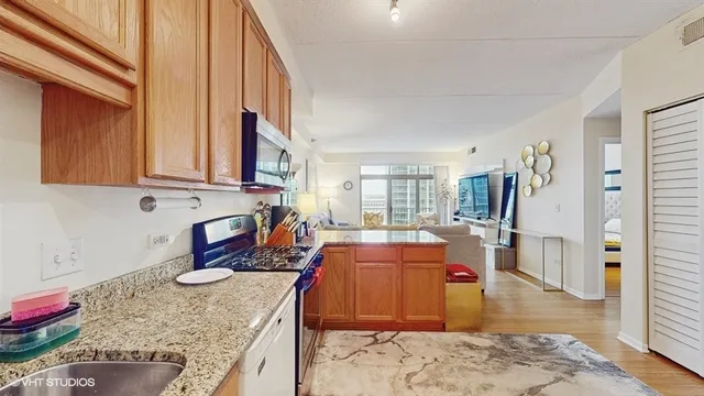 a large kitchen with stainless steel appliances granite countertop a sink stove and refrigerator