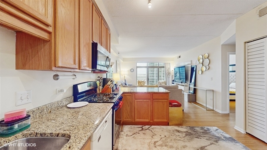 1250 South Indiana Avenue, Unit 1002 Chicago, IL 60605 - Photo 13 of 25 a large kitchen with stainless steel appliances granite countertop a sink stove and refrigerator