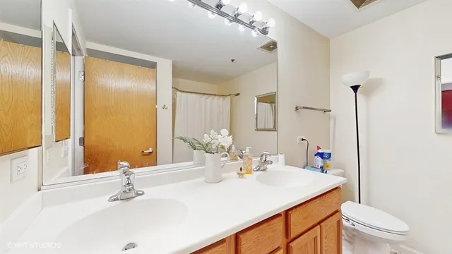 a bathroom with a sink vanity mirror and toilet