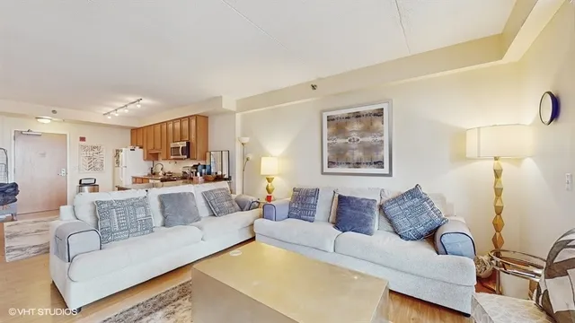 a living room with furniture and a view of kitchen