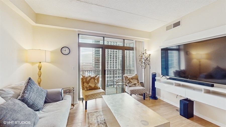 1250 South Indiana Avenue, Unit 1002 Chicago, IL 60605 - Photo 5 of 25 a living room with furniture and a flat screen tv