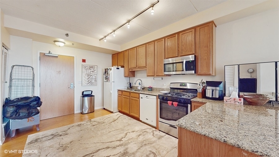 1250 South Indiana Avenue, Unit 1002 Chicago, IL 60605 - Photo 9 of 25 a kitchen with stainless steel appliances granite countertop a stove refrigerator sink and cabinets