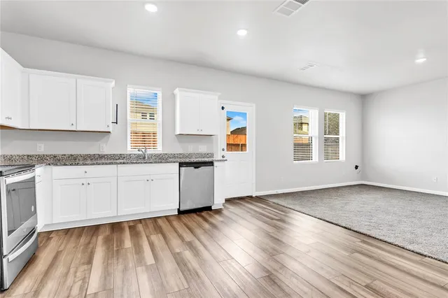 a kitchen with granite countertop white cabinets and white appliances