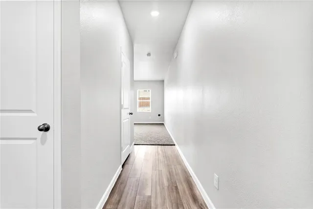 a view of a hallway with wooden floor