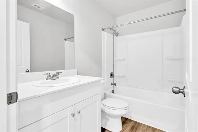 a bathroom with a sink a toilet a mirror a bathtub and shower