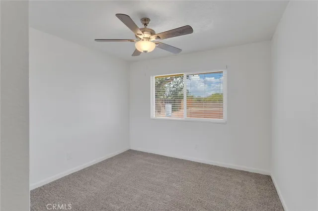 an empty room with window and fan
