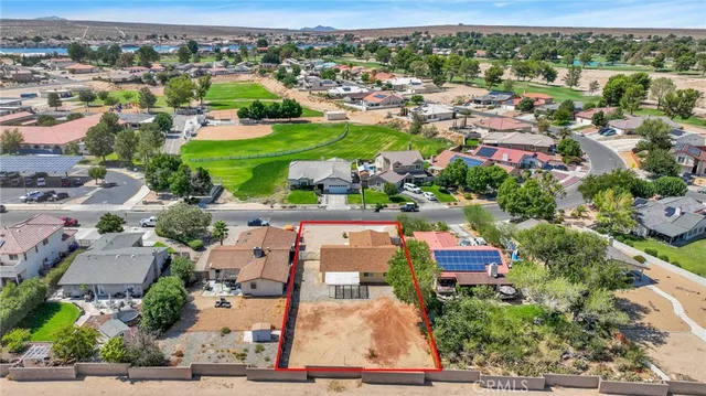 an aerial view of residential houses with outdoor space and trees
