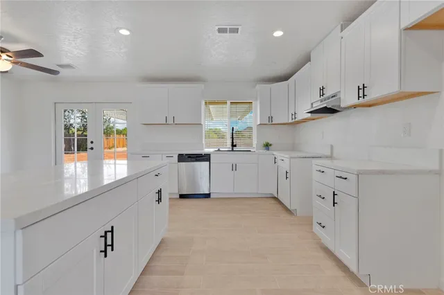 a kitchen with white cabinets and white appliances