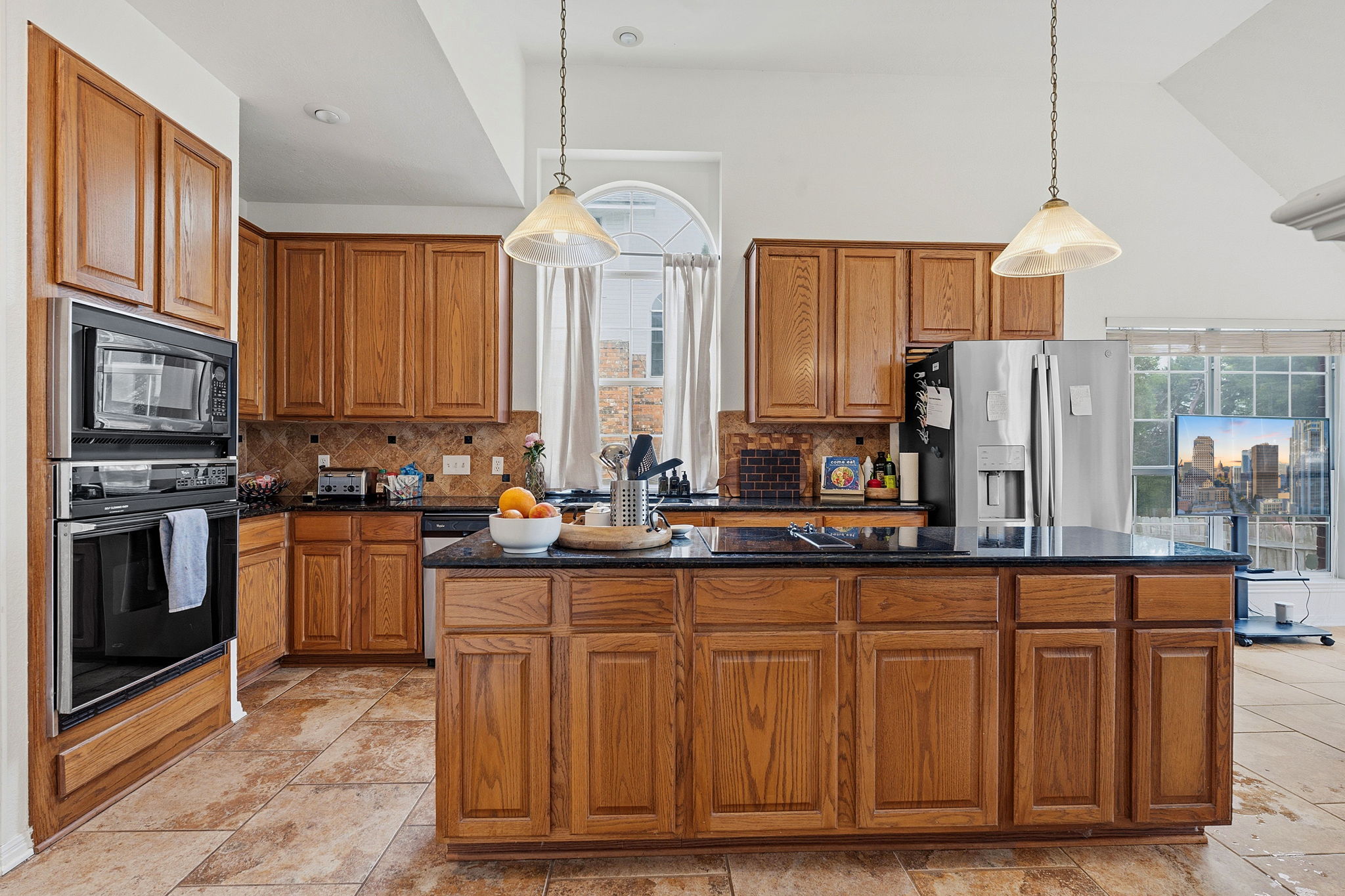 8317 Pommel Drive Austin, TX 78759 - Photo 7 of 26 A well-appointed kitchen features rich wood cabinetry, integrated appliances, and a central island with a sleek cooktop.