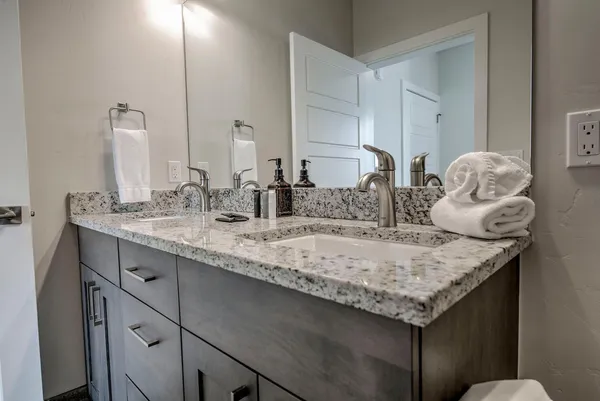 a bathroom with a granite countertop sink and a mirror