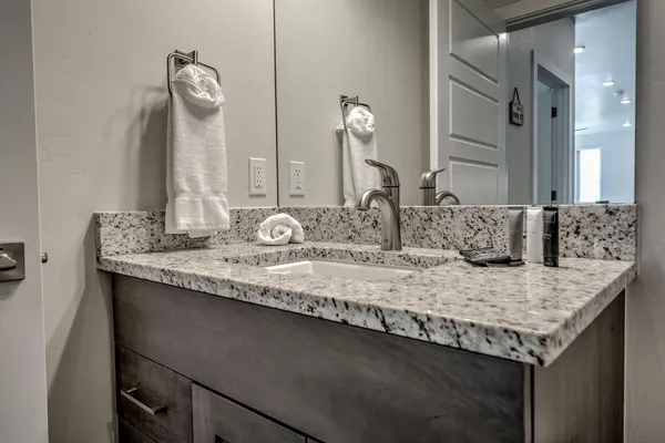 a bathroom with a granite countertop sink and a mirror