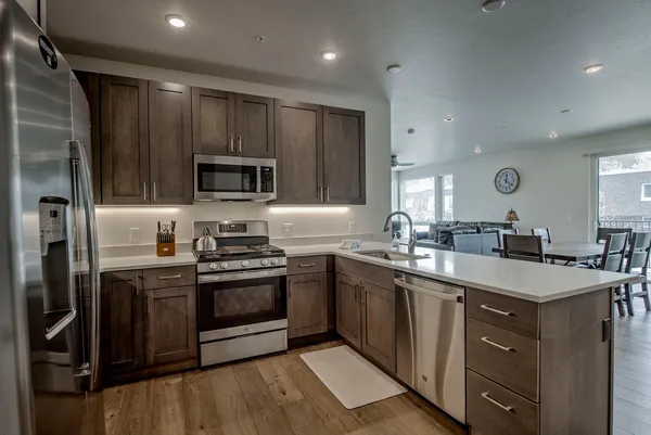 a kitchen with stainless steel appliances granite countertop a sink stove microwave and refrigerator