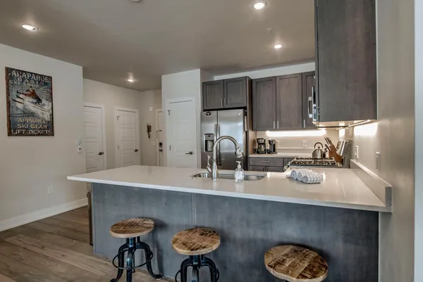 a kitchen with a sink cabinets and wooden floor
