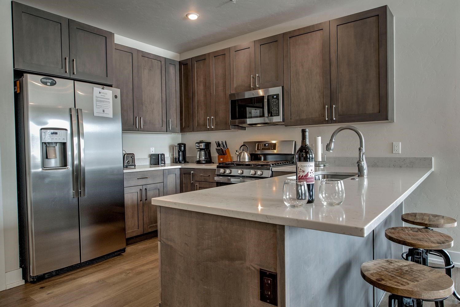 235 La Bonte Street, Unit 108 Dillon, CO 80435 - Photo 9 of 38 a kitchen with stainless steel appliances granite countertop a stove a sink dishwasher and a refrigerator with wooden floor