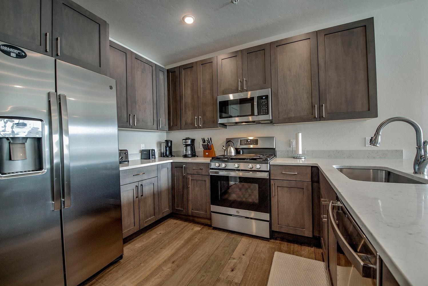 235 La Bonte Street, Unit 108 Dillon, CO 80435 - Photo 10 of 38 a kitchen with stainless steel appliances granite countertop a refrigerator a sink a stove a microwave and wooden cabinets