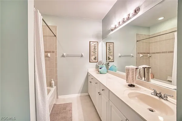 a spacious bathroom with a double vanity sink a mirror and a shower