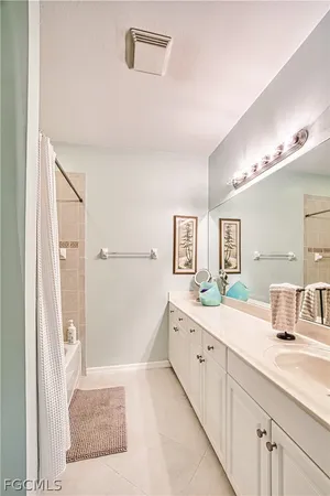 a spacious bathroom with a double vanity sink a mirror and a shower