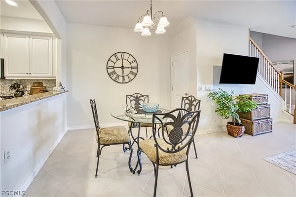 a view of a dining room with furniture a chandelier and a window